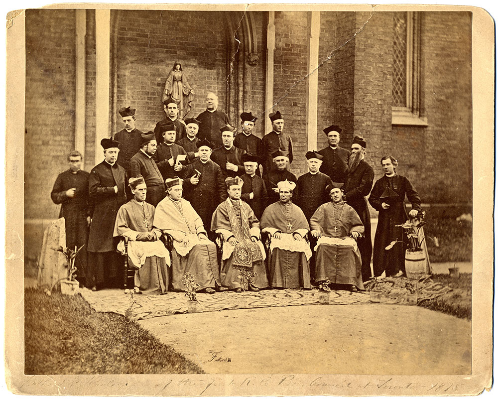 Black-and-white group of bishops and priests in episcopal dress in front of St. Michael's Cathedral.