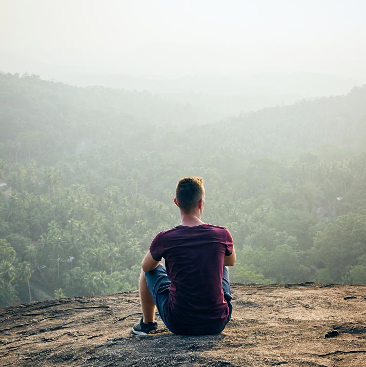 Man Sitting Looking at Mountains