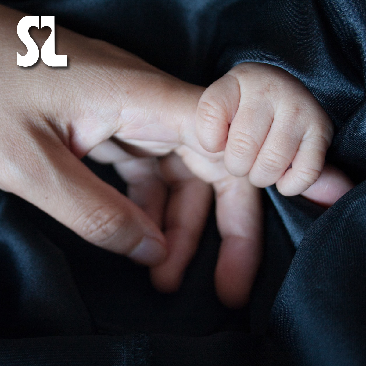 The hands of a caregiver and baby
