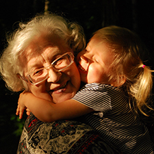 Grandmother being hugged joyfully by a granddaughter
