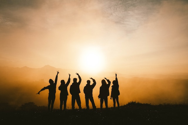 Friends posing for photo in front of sunset