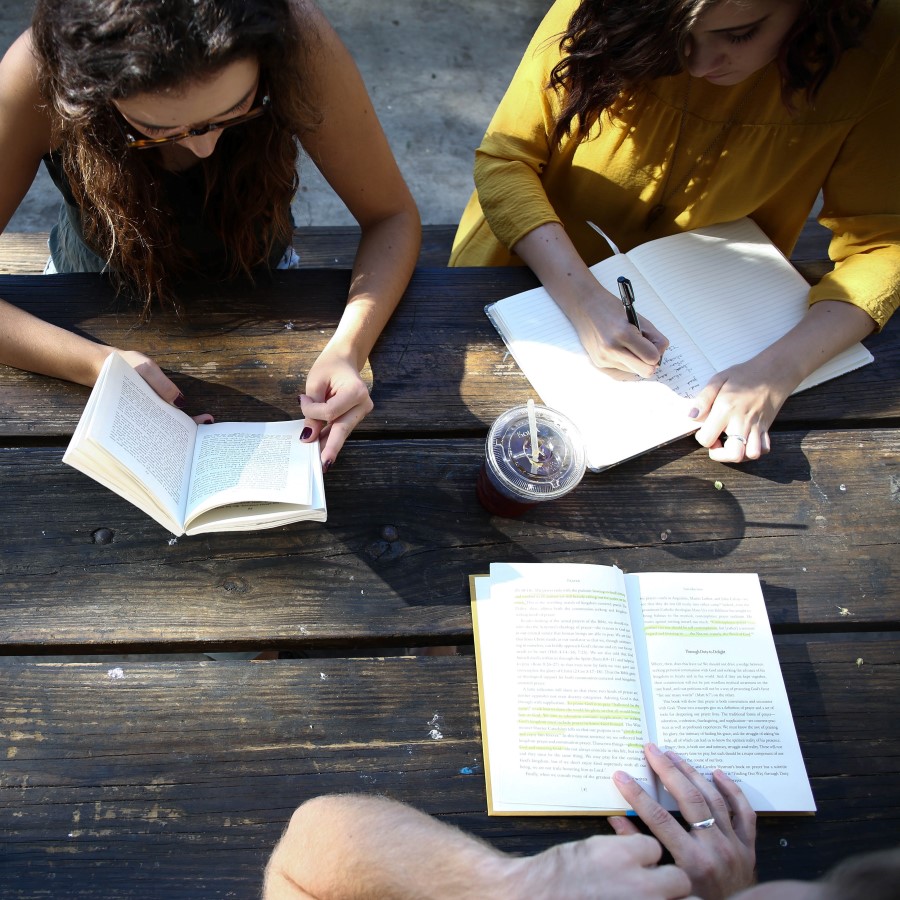 Three People Sitting and Reading