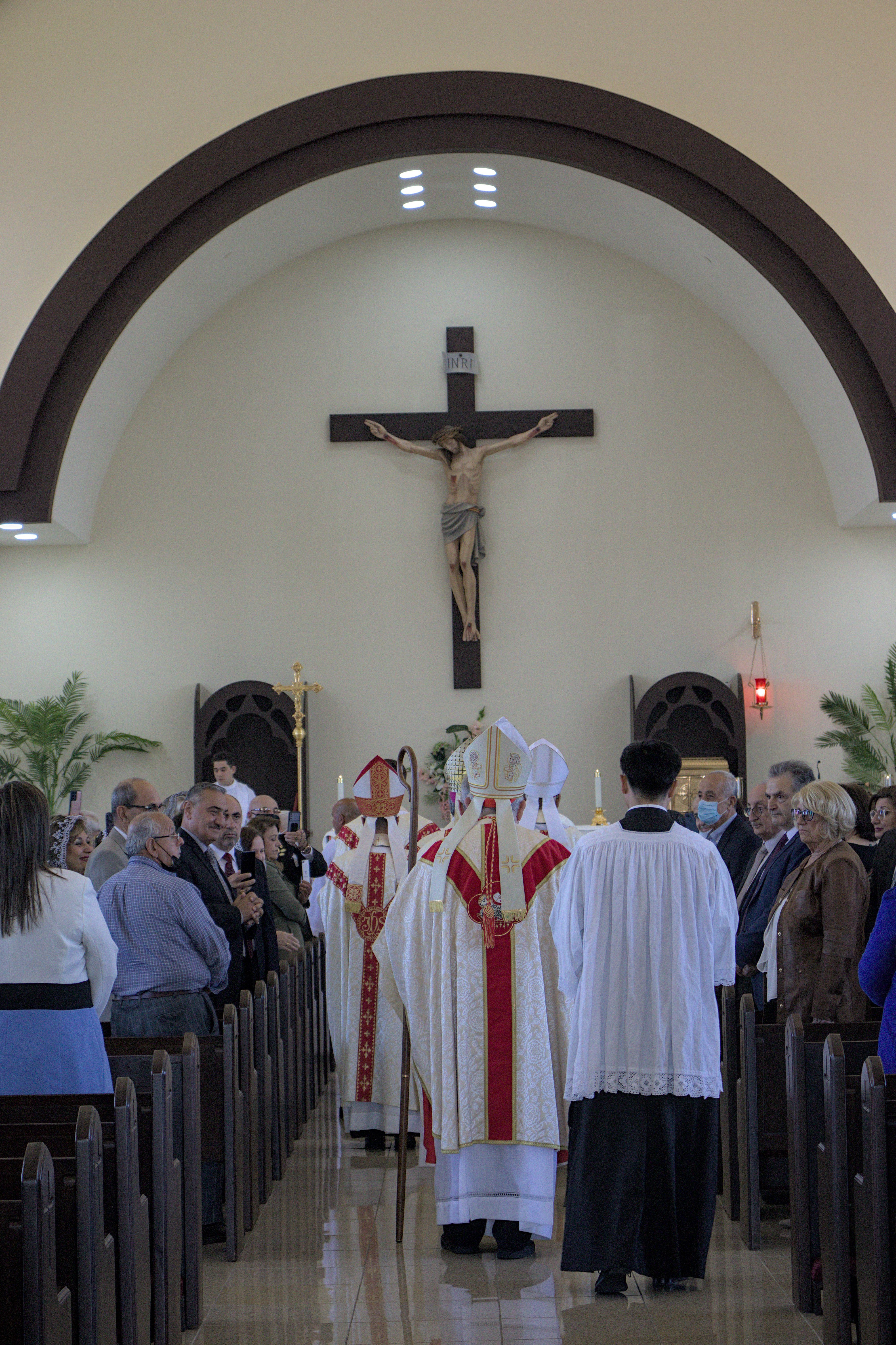 People attending Mass looking at the procession