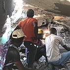 Men stand in the ruins of a destroyed building in Haiti