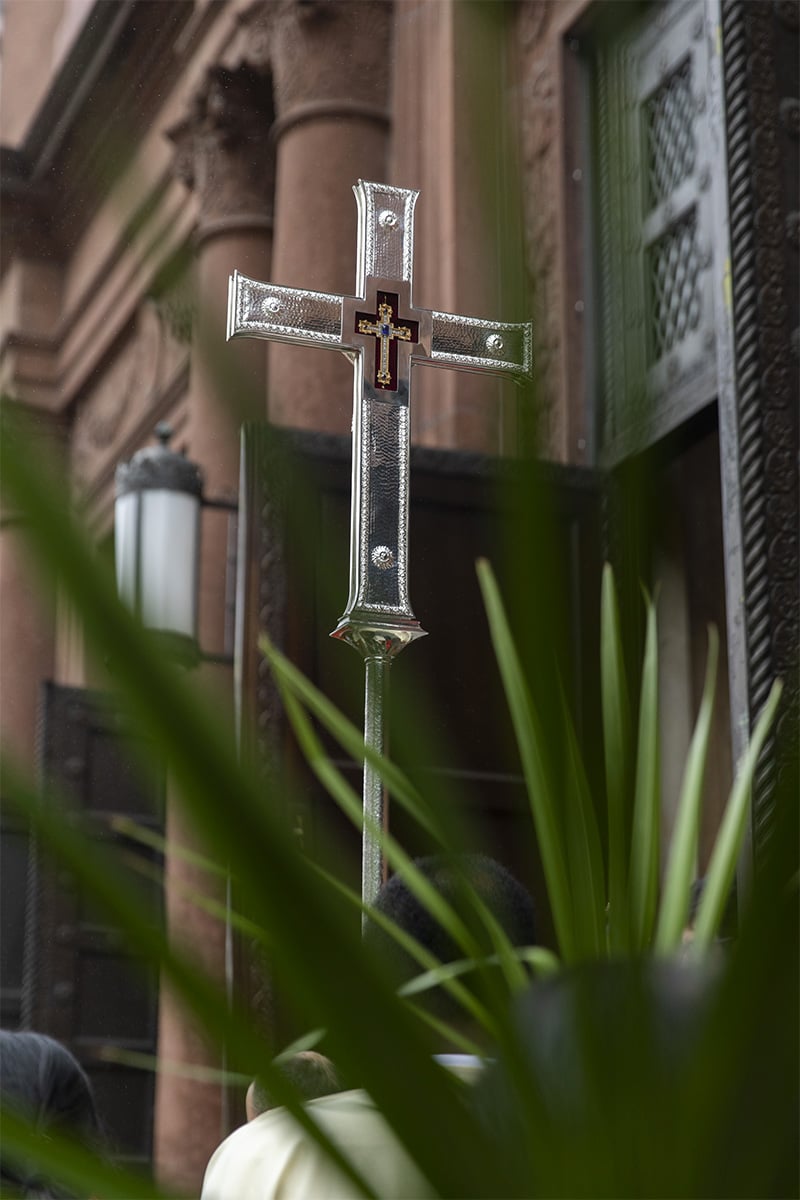 A cross with palm leaves in the foreground