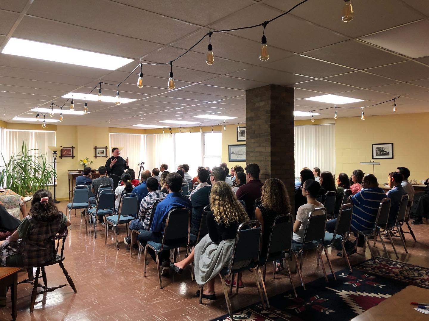 Group of young adults seated while listening to their guest speaker