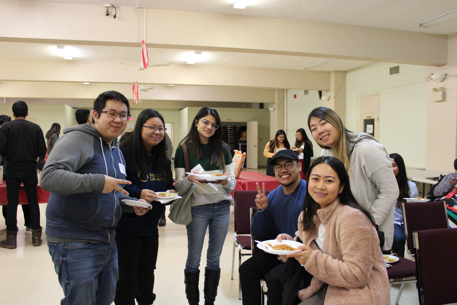 Group of multicultural young adults gathered over conversation and food