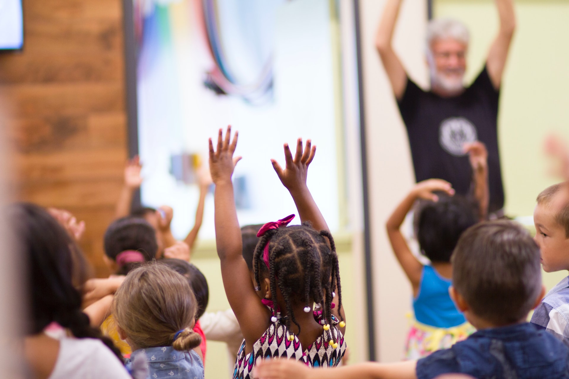 A group of young children reaching for the sky in a parish hall