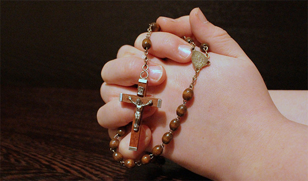 Praying hands with rosary