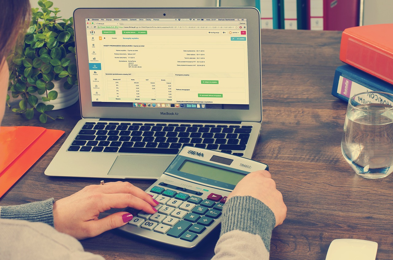 A woman sits in front of a computer, doing taxes