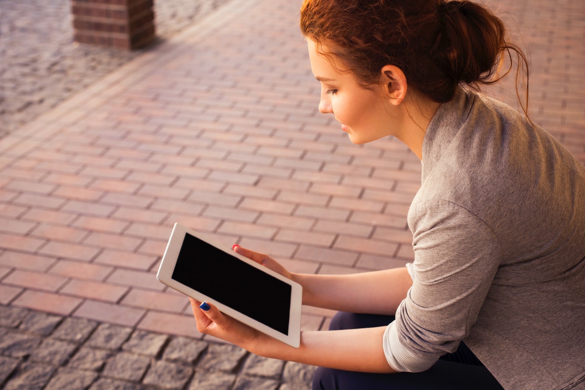 A woman read a tablet device on a sunny day