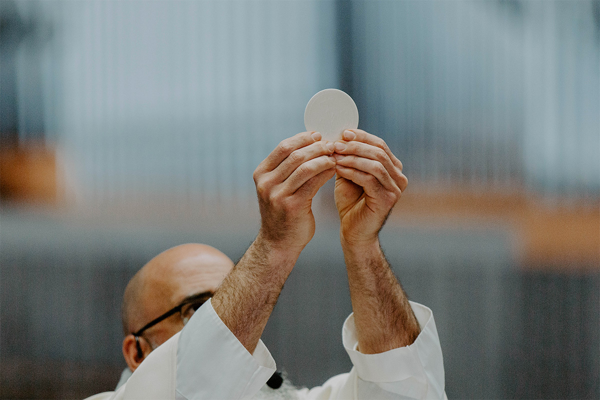 A priest lifts the Communion high