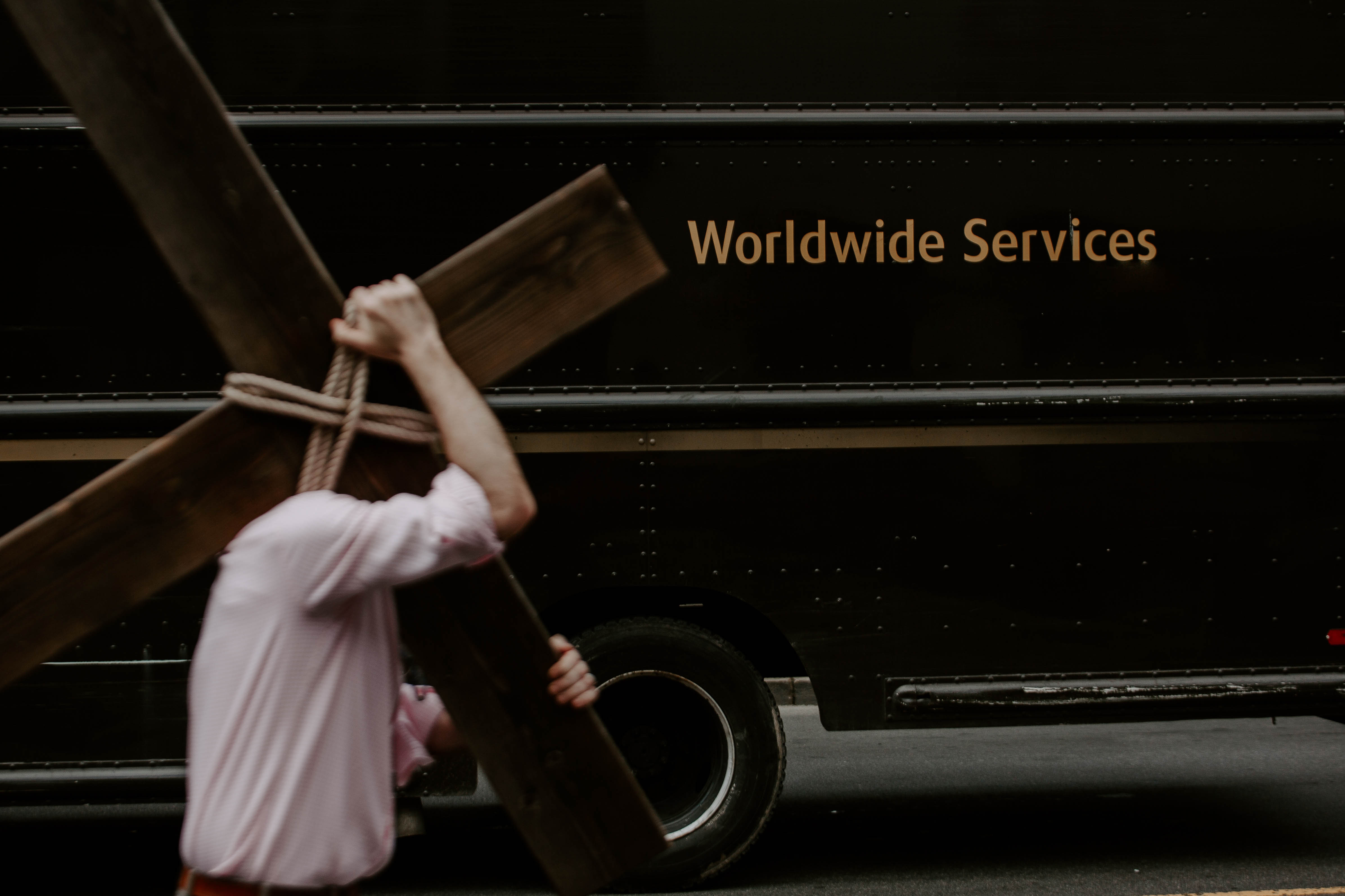 A man carries a cross in a modern city's downtown core
