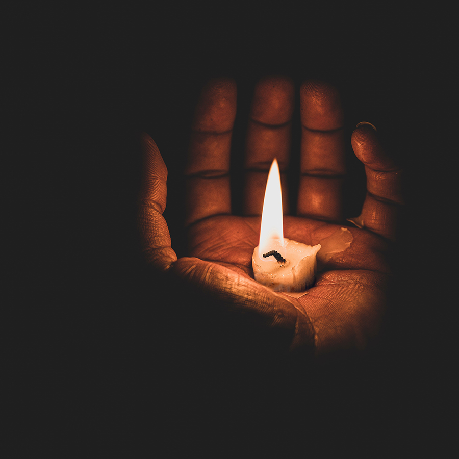 Open hand with a lit candle