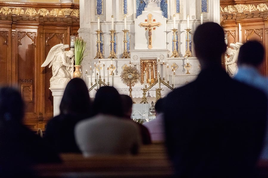 Group of people praying at church during adoration