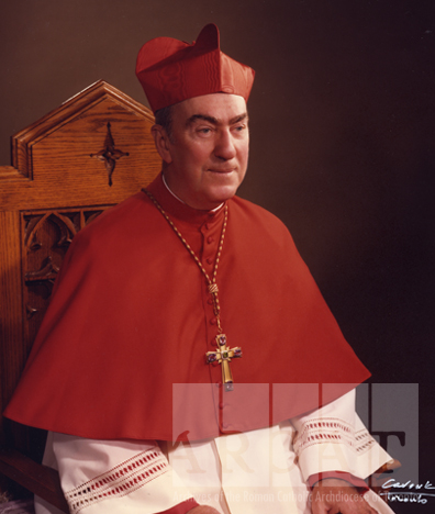 Portrait of His Eminence, Gerald Emmett Cardinal Carter, seated wearing episcopal dress.