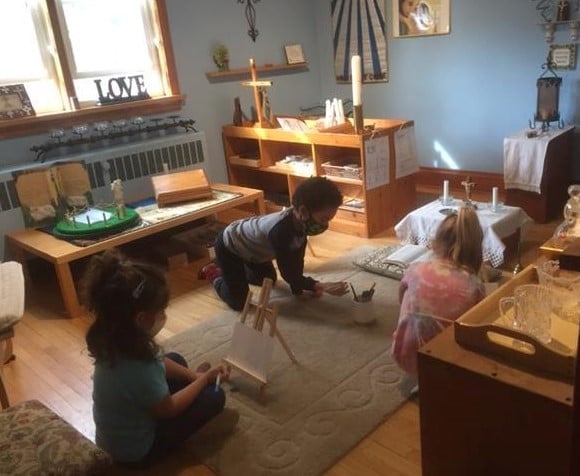 Children painting in front of Prayer table