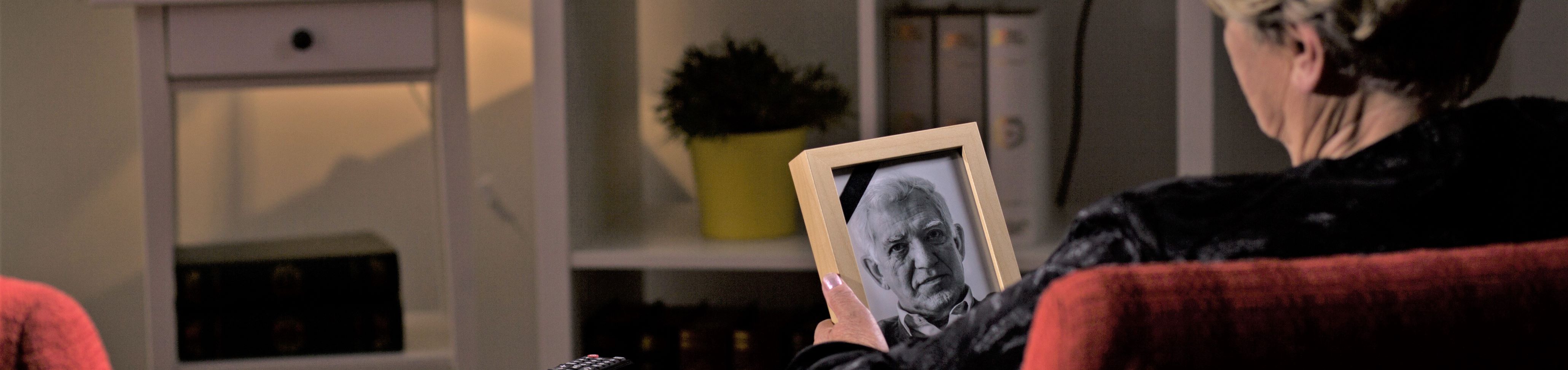 Woman holding photo of deceased husband