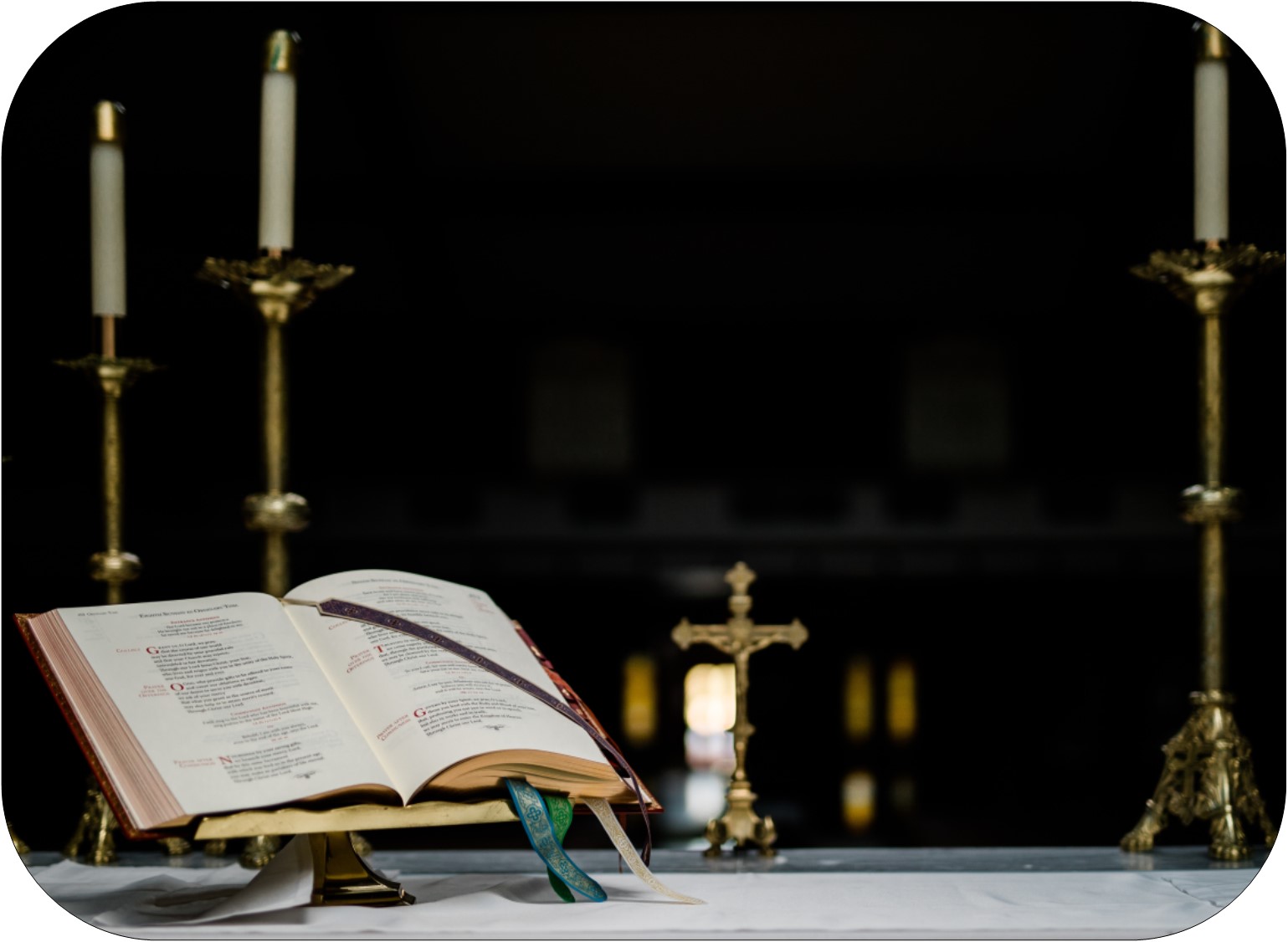 altar with candles, gold cross on a stand, and open lectionary