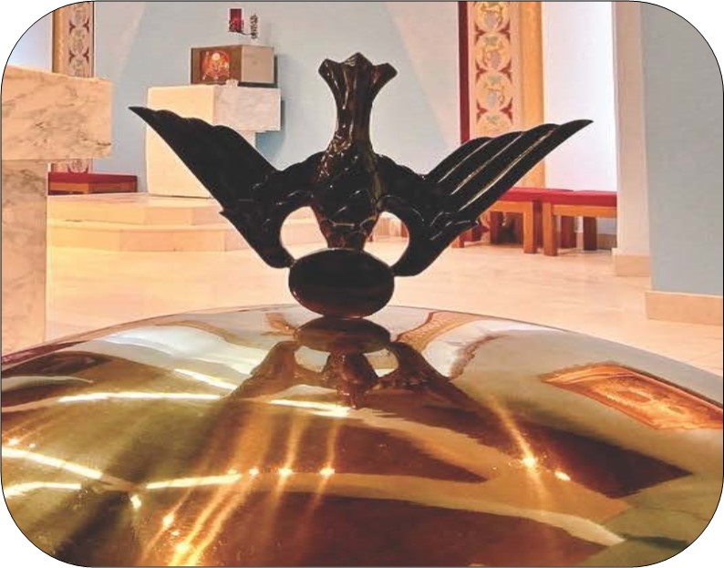 image of golden lid of a baptismal font with a handle in the shape of a dove flying downwards