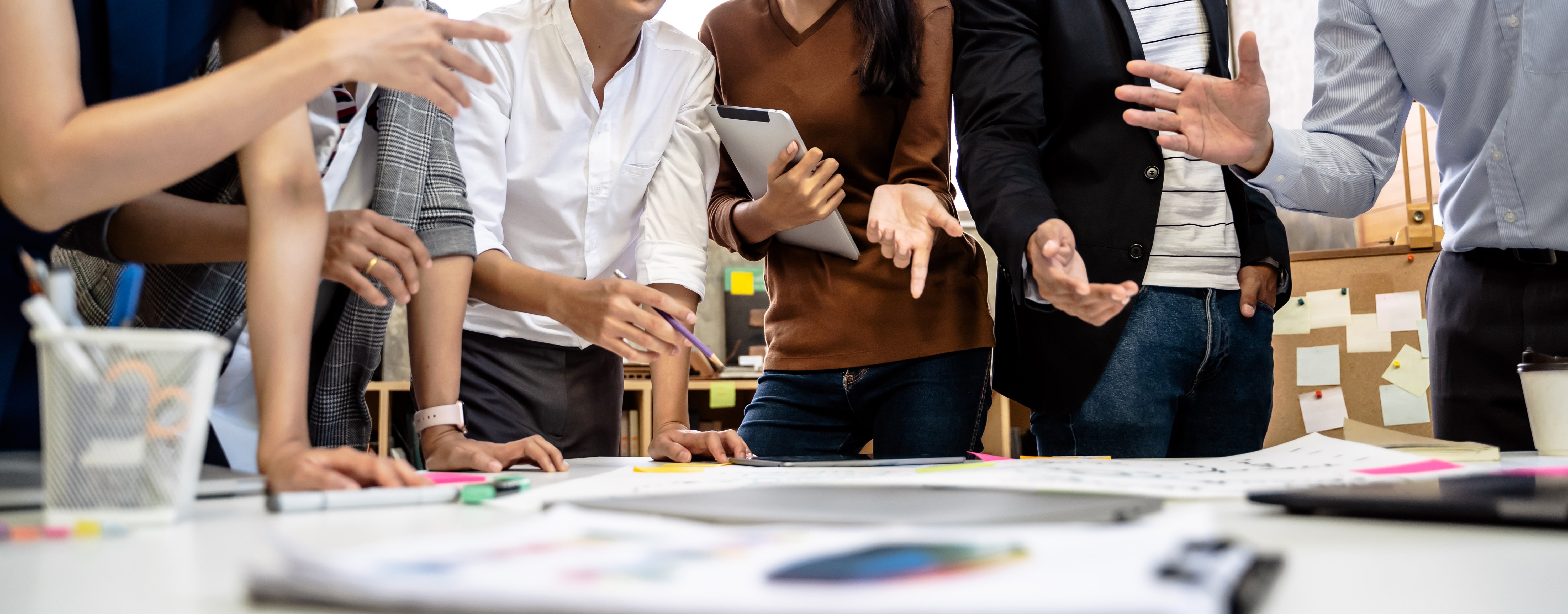 image of people around a table looking at a computer and print outs