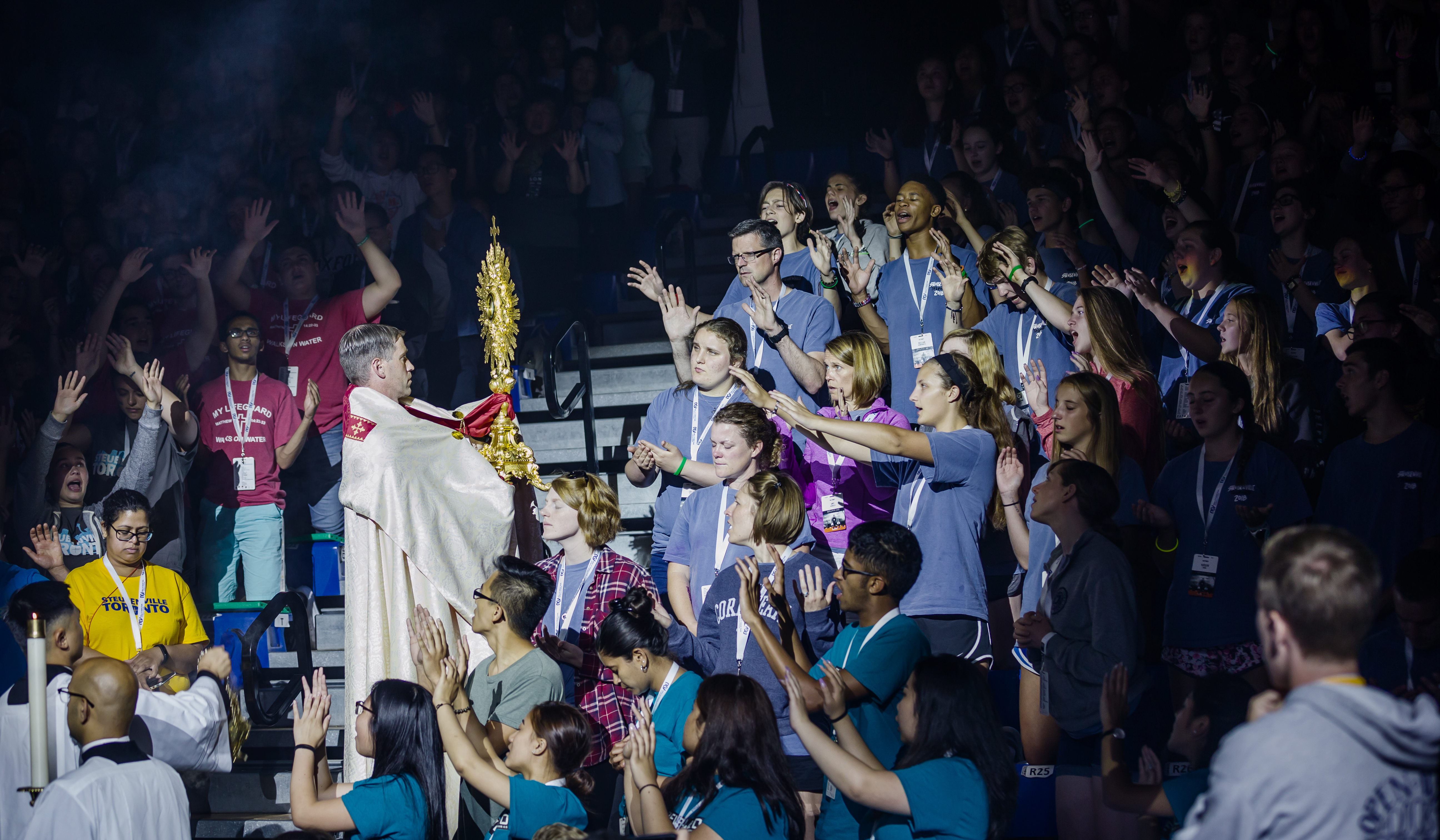 A stadium full of young people venerating, praying and singing praise to Jesus Christ in Eucharistic Adoration