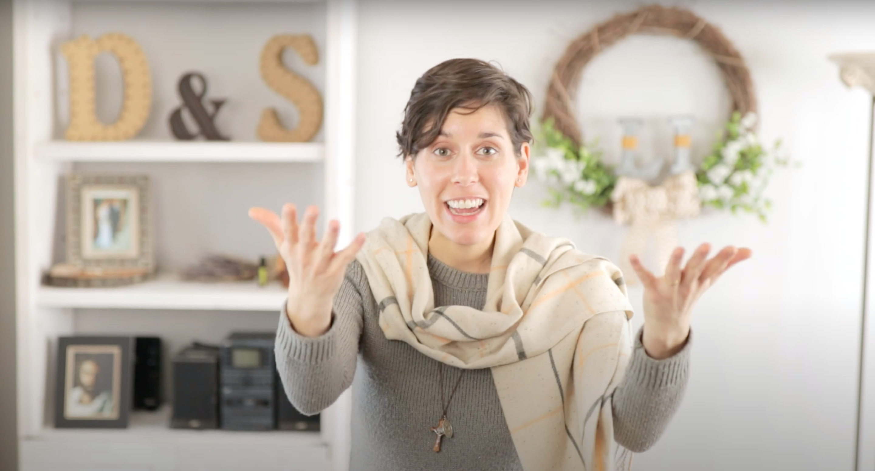 Young woman excitedly raising her hands as she expressively explains and speaks to her audience