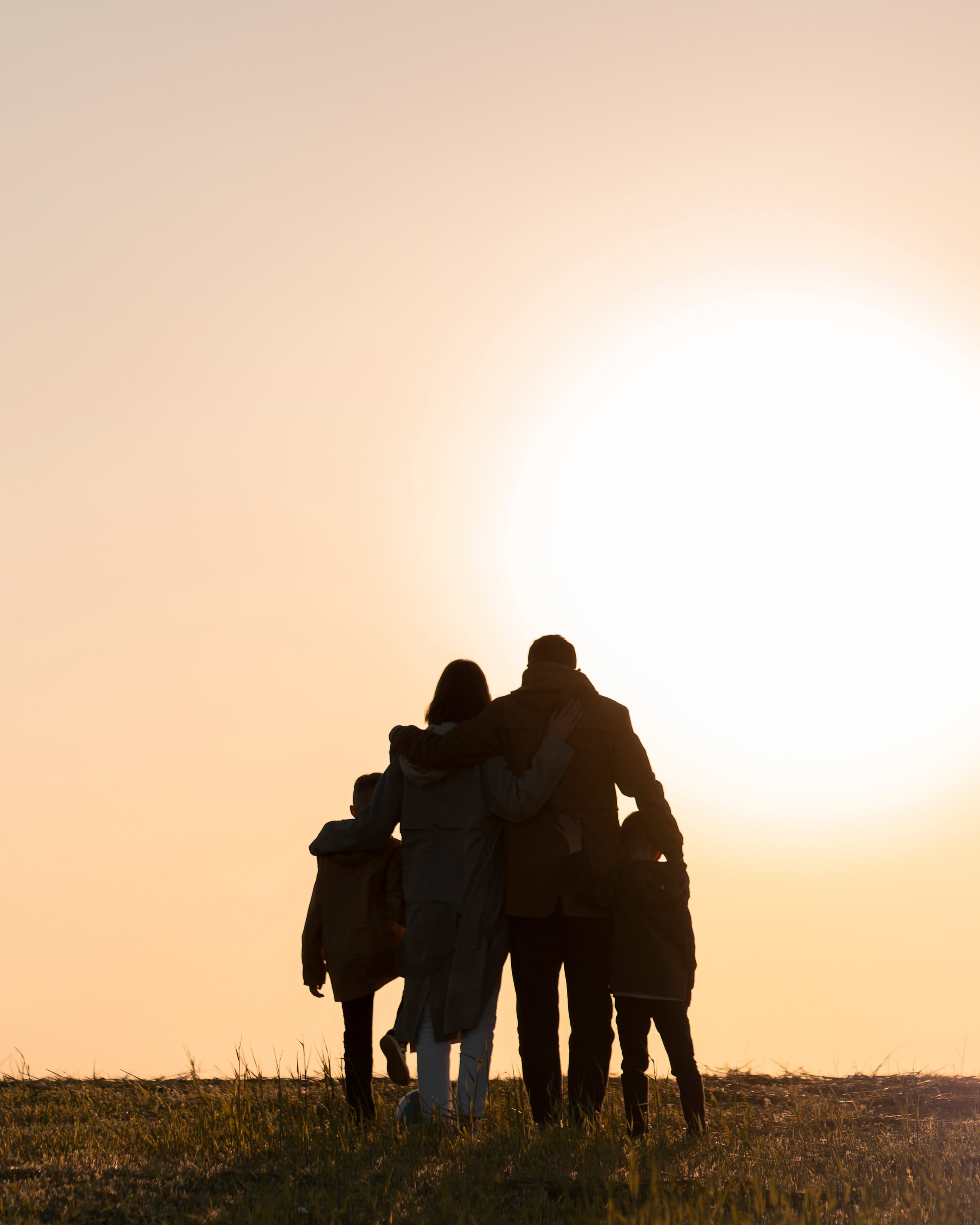 Family silhouette having fun at sunset