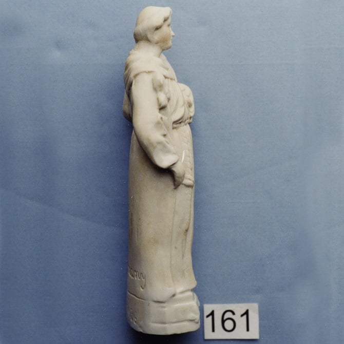 White religious figurine of an unidentified person viewed from the side