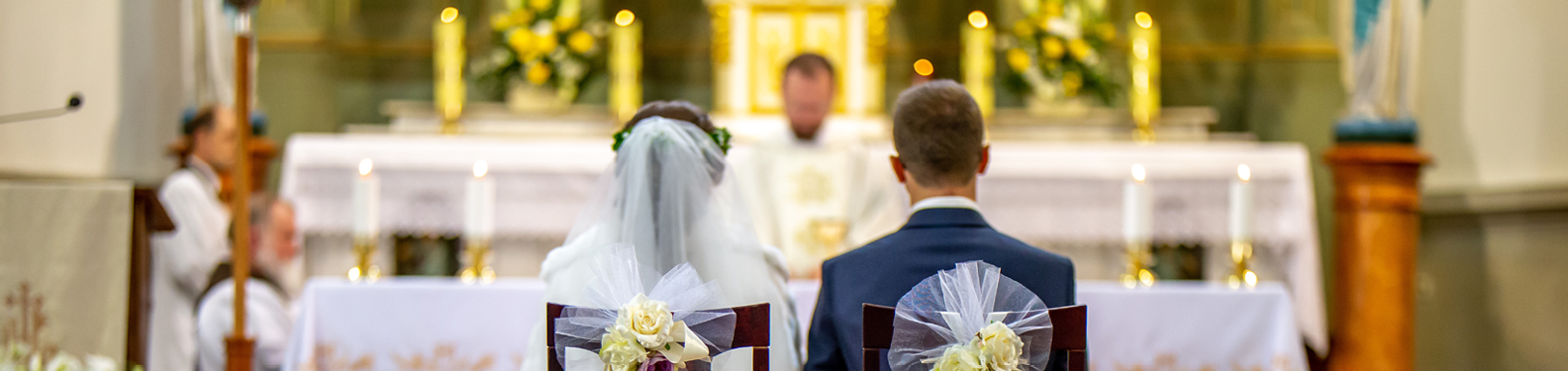 wedding ceremony, couple sitting on chairs in front of sanctuary, view from the back