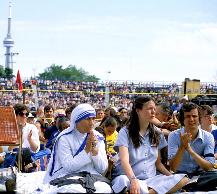 Mother Teresa sitting with crowd in Toronto