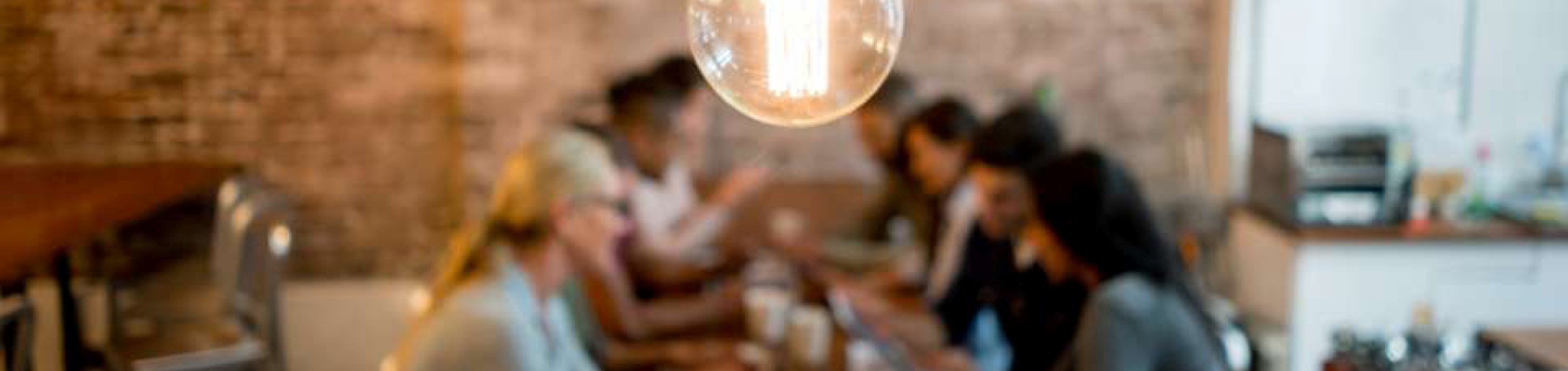 people sitting at table with a light bulb above