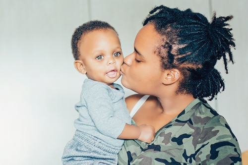 Image of Mom kissing young child