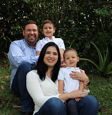 A family family poses for a photo outside: a mother, father and two young sons