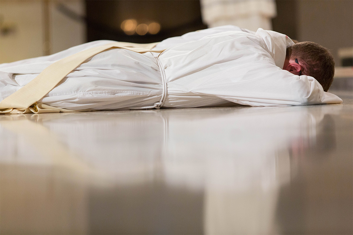 A priest lays on the ground during Holy Orders